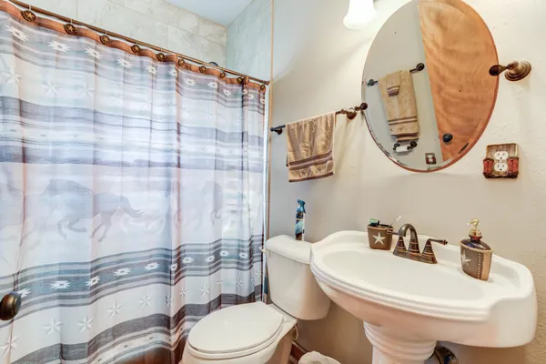 a white toilet sitting next to a bathroom sink and a mirror