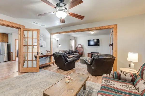 a living room with furniture a ceiling fan and a window