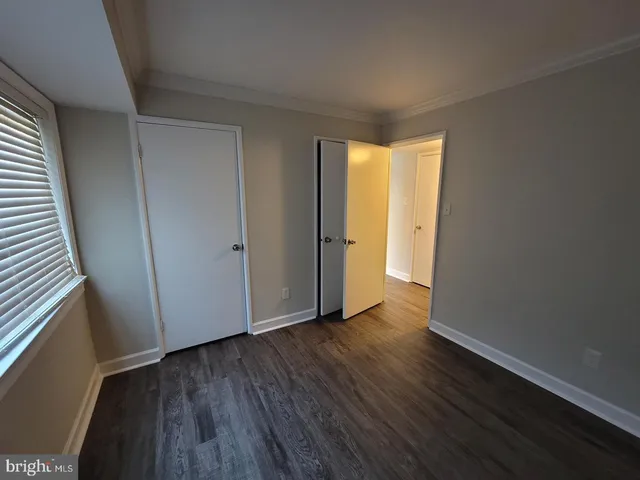 an empty room with wooden floor and entrance