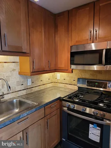 a kitchen with granite countertop a stove and a sink
