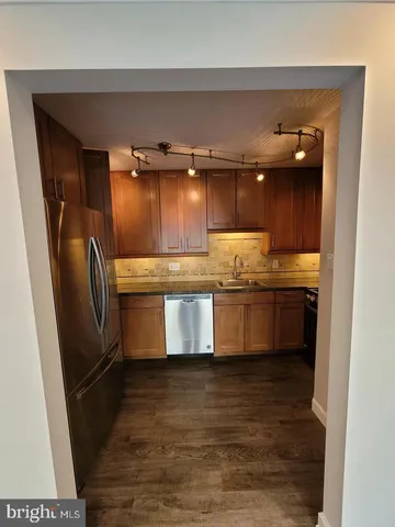 a large kitchen with granite countertop a stove a sink and a refrigerator