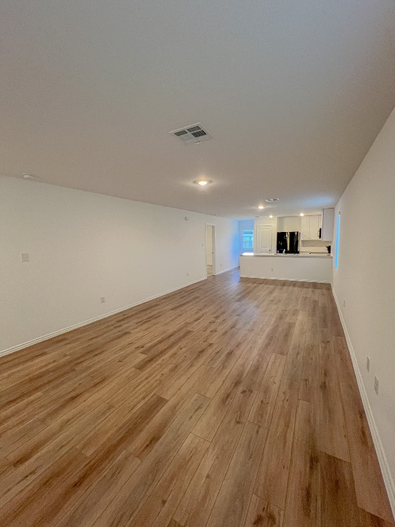 129 Hellcats Way Jarrell, TX 76537 - Photo 3 of 19 Unfurnished living room featuring light wood-type flooring and baseboards