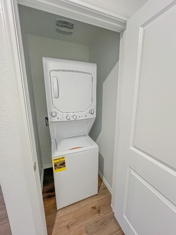 129 Hellcats Way Jarrell, TX 76537 - Photo 8 of 19 Washroom with light wood finished floors and estacked washer and dryer