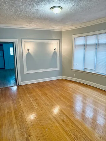 an empty room with wooden floor and door