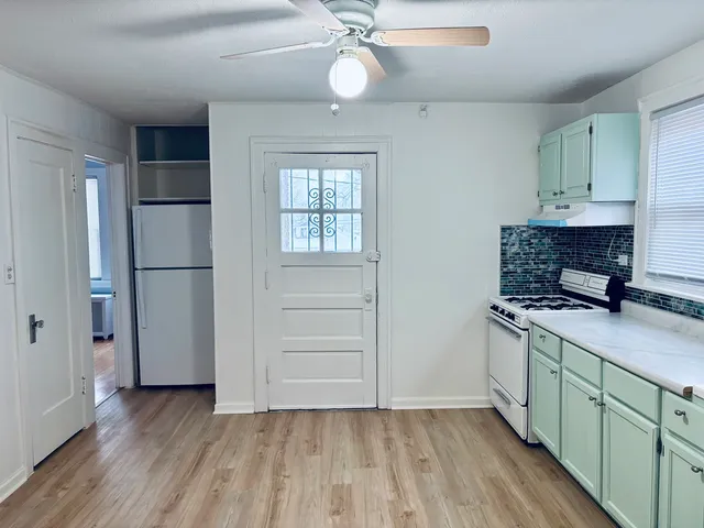 a kitchen with a refrigerator and a stove top oven