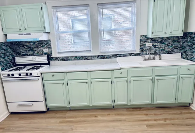 a kitchen with a sink cabinets and a stove