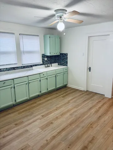 a room with lots of wooden cabinets and a sink
