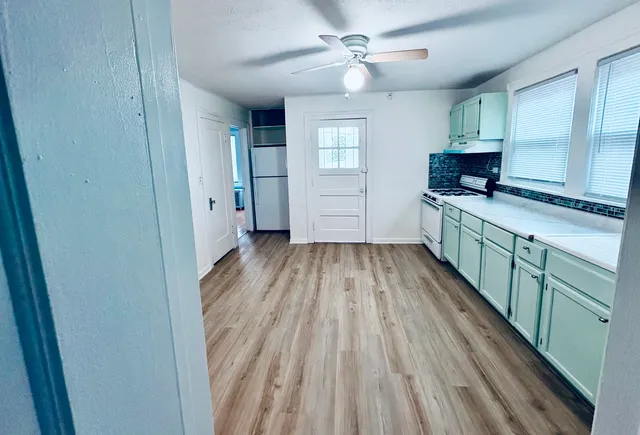 a view of a kitchen with wooden floor a sink and a window