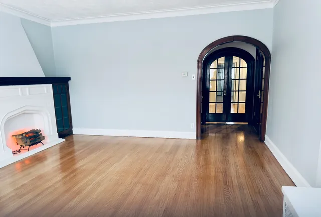 an empty room with wooden floor and natural light