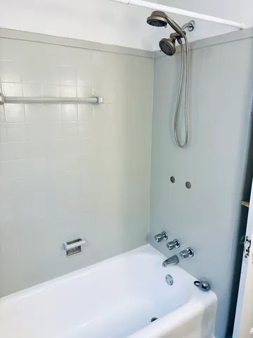 a bathroom with a bath tub with a shower