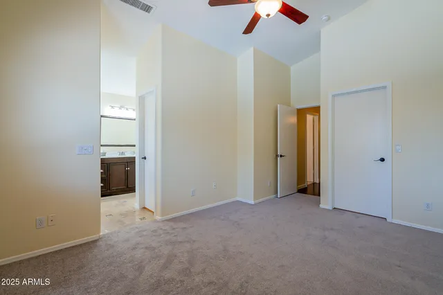 an empty room with ceiling fan and window