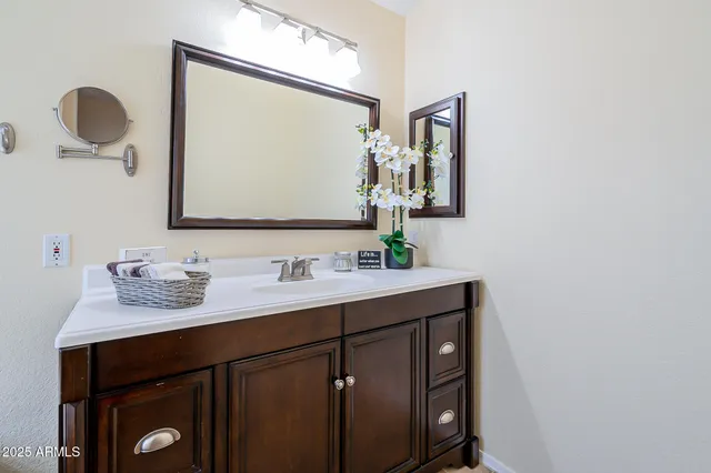 a bathroom with a granite countertop sink and a mirror