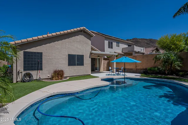 a view of a house with swimming pool and sitting area