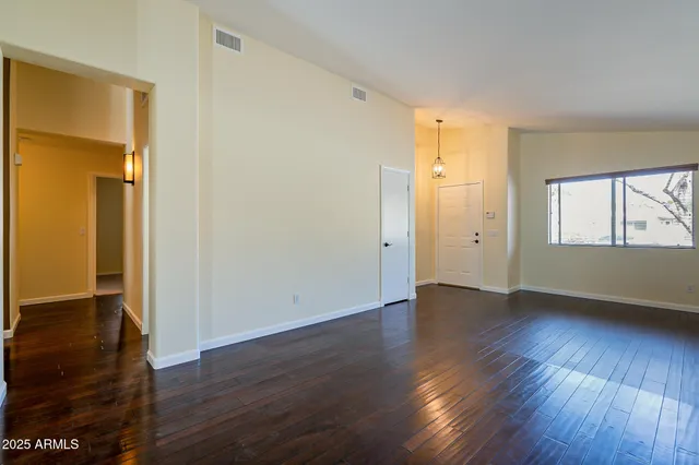 a view of a big room with wooden floor and windows