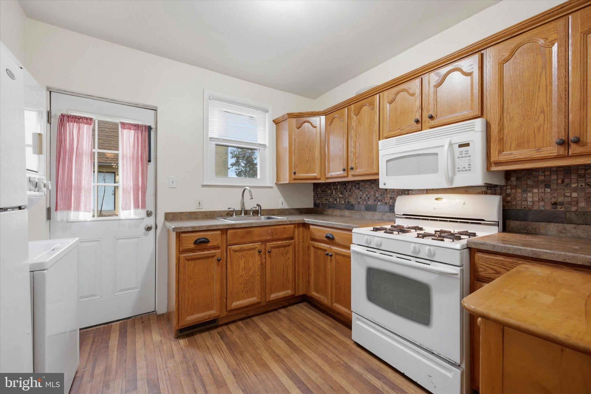7 Rhodes Avenue Collingdale, PA 19023 - Photo 8 of 27 a kitchen with stainless steel appliances granite countertop a stove a sink and white cabinets