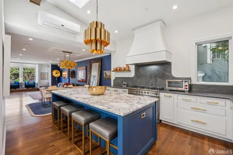 a kitchen with a stove a sink a kitchen island with a dining table and chairs