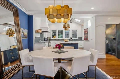 a kitchen with a dining table chairs and chandelier