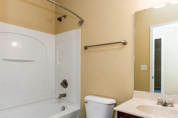 a bathroom with a sink a toilet a mirror a bathtub and shower