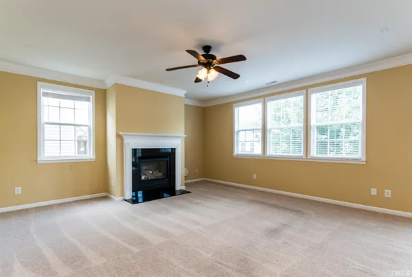 a view of an empty room with a fireplace and a window