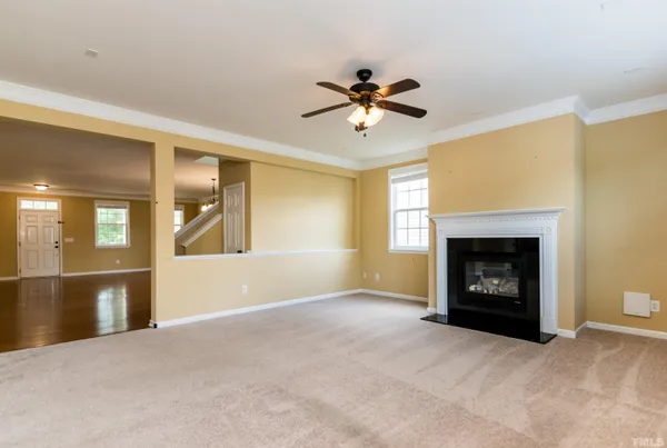 a view of a kitchen with a stove cabinets a ceiling fan and wooden floor