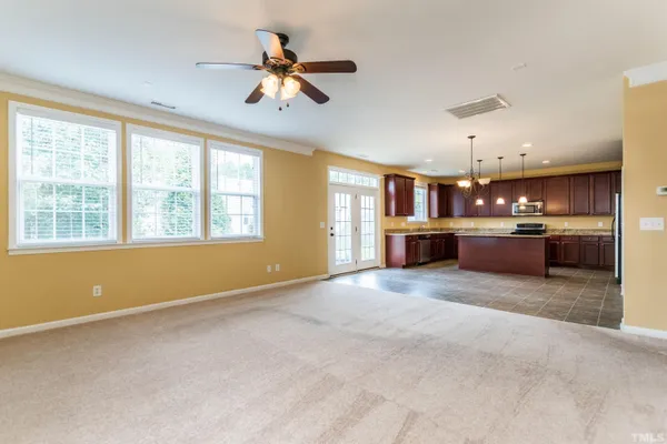 an empty room with a window and a fan