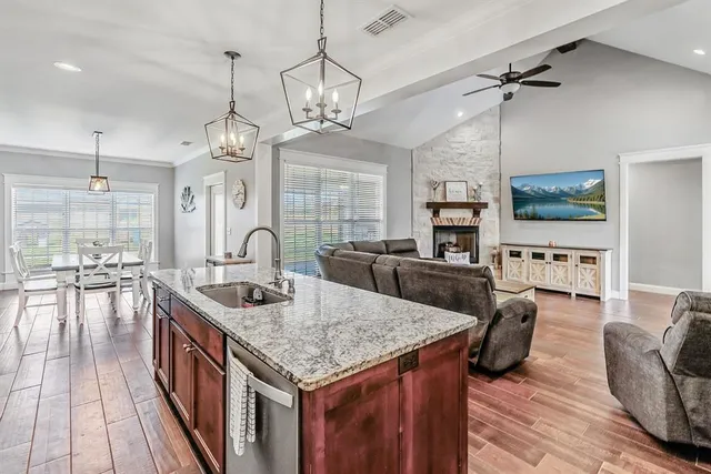 a large kitchen with sink a refrigerator and chairs
