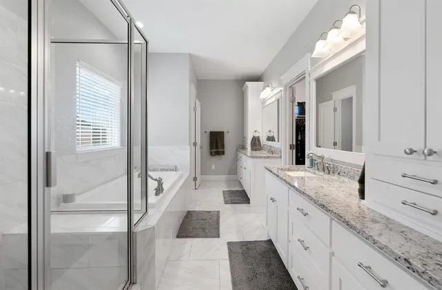 a large white kitchen with a sink and dishwasher with wooden floor