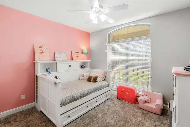 a bathroom with a granite countertop toilet a sink and a window