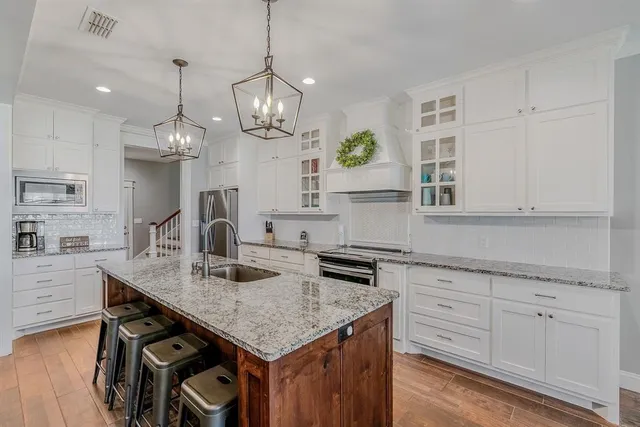 a kitchen with granite countertop a table chairs and cabinets