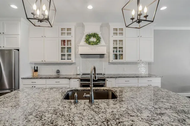 a kitchen with granite countertop a sink a counter and cabinets