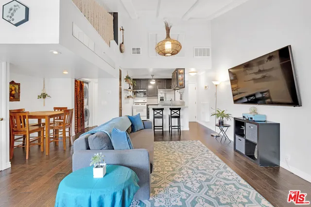 a living room with furniture kitchen view and a flat screen tv