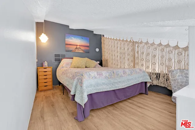 a bedroom with a bed and a wooden floor