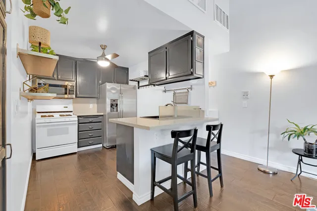 a kitchen with a table chairs refrigerator and microwave