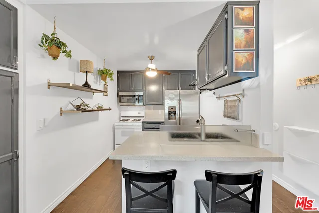 a kitchen with stainless steel appliances granite countertop a sink refrigerator and cabinets
