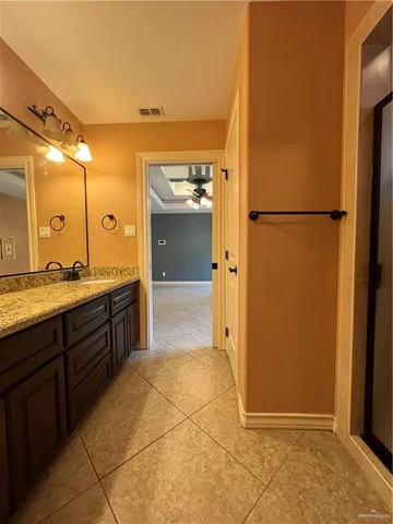 a spacious bathroom with a granite countertop sink mirror and shower