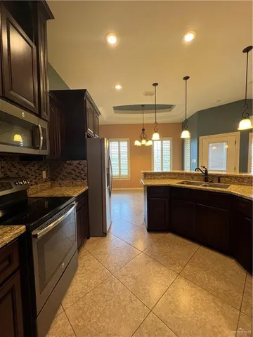 a kitchen with stainless steel appliances kitchen island granite countertop a refrigerator and a sink