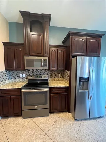 a kitchen with granite countertop stainless steel appliances and wooden cabinets