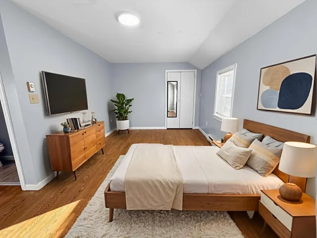 a spacious bedroom with a bed and a flat screen tv