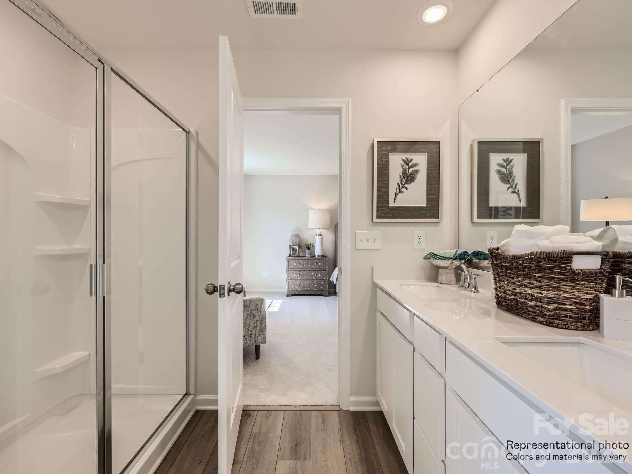 143 Spotted Way Troutman, NC 28166 - Photo 19 of 24 a bathroom with a sink a mirror and a shower