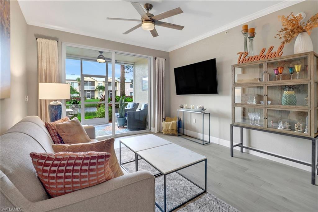 20261 Estero Gardens Circle, Unit 104 Estero, FL 33928 - Photo 13 of 50 Living room featuring ceiling fan, crown molding, and hardwood / wood-style flooring
