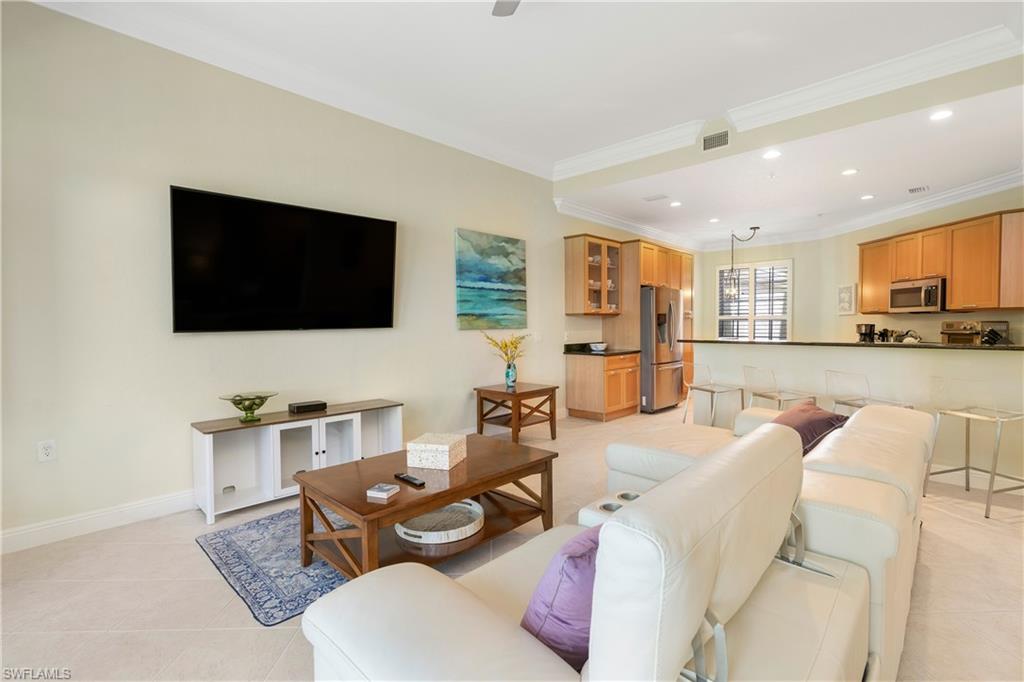 9259 Museo Circle, Unit 7102 Naples, FL 34114 - Photo 11 of 41 a living room with furniture and a flat screen tv