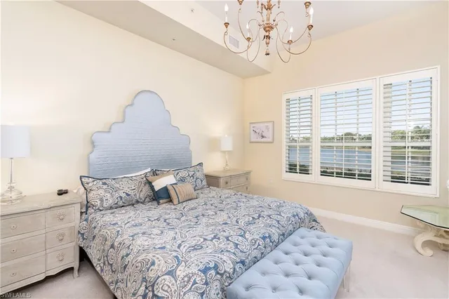 a bedroom with a large bed and a chandelier