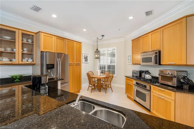 a kitchen with stainless steel appliances granite countertop sink stove top oven and cabinets