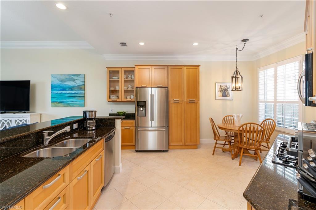 9259 Museo Circle, Unit 7102 Naples, FL 34114 - Photo 8 of 41 a kitchen with stainless steel appliances granite countertop a sink stove and refrigerator