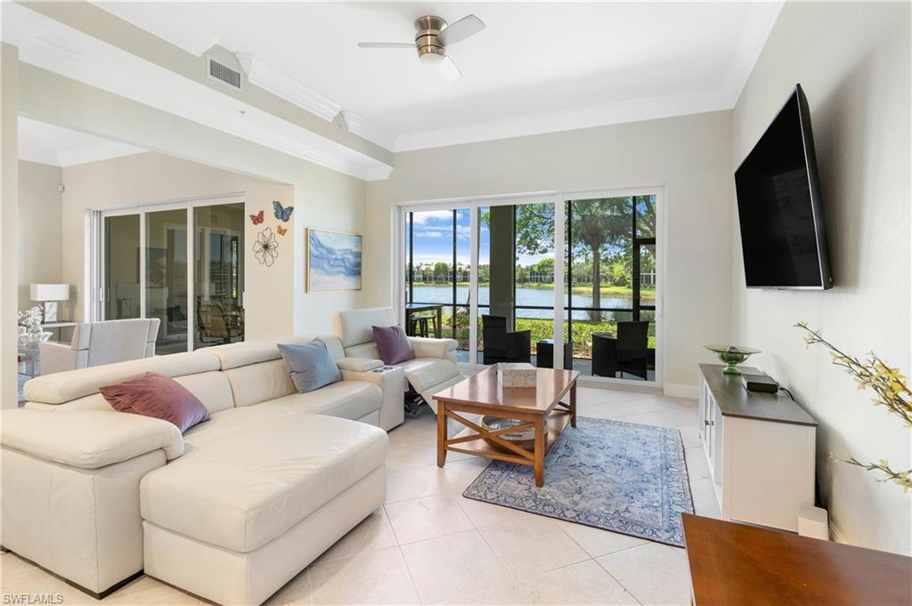 9259 Museo Circle, Unit 7102 Naples, FL 34114 - Photo 9 of 41 a living room with furniture floor to ceiling window hardwood floor and a flat screen tv