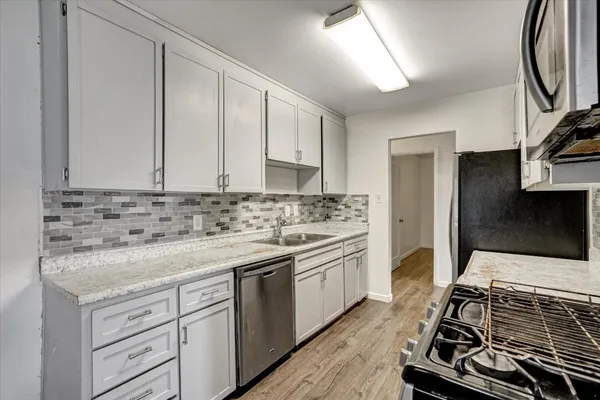 a kitchen with a sink stove and cabinets