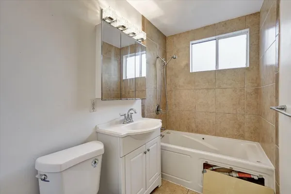 a bathroom with a sink a toilet tub and shower