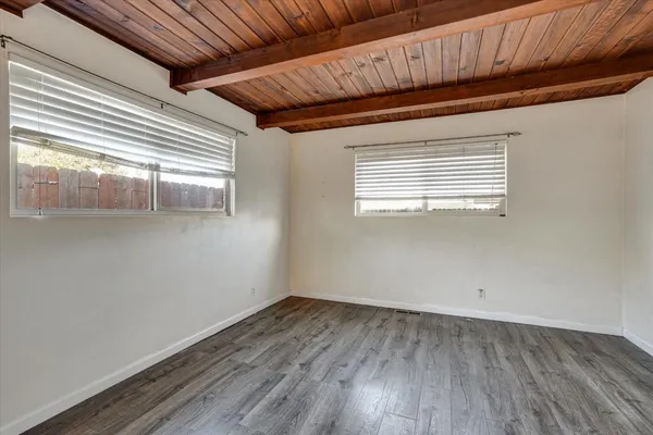 a view of a room with wooden floors and ceiling fan