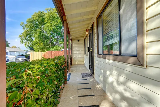 a view of a pathway of a house with potted plants
