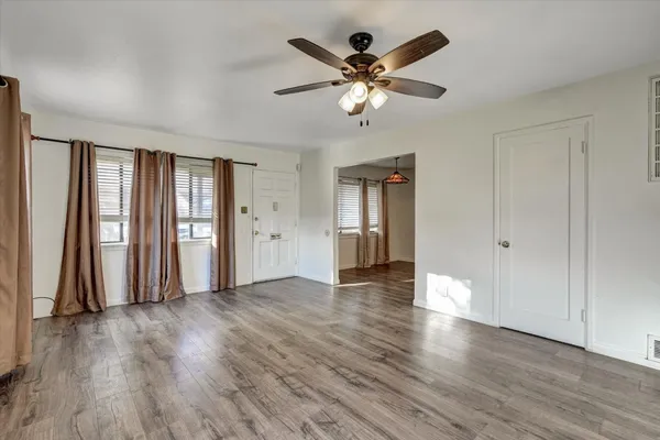 a view of a livingroom with wooden floor and a ceiling fan